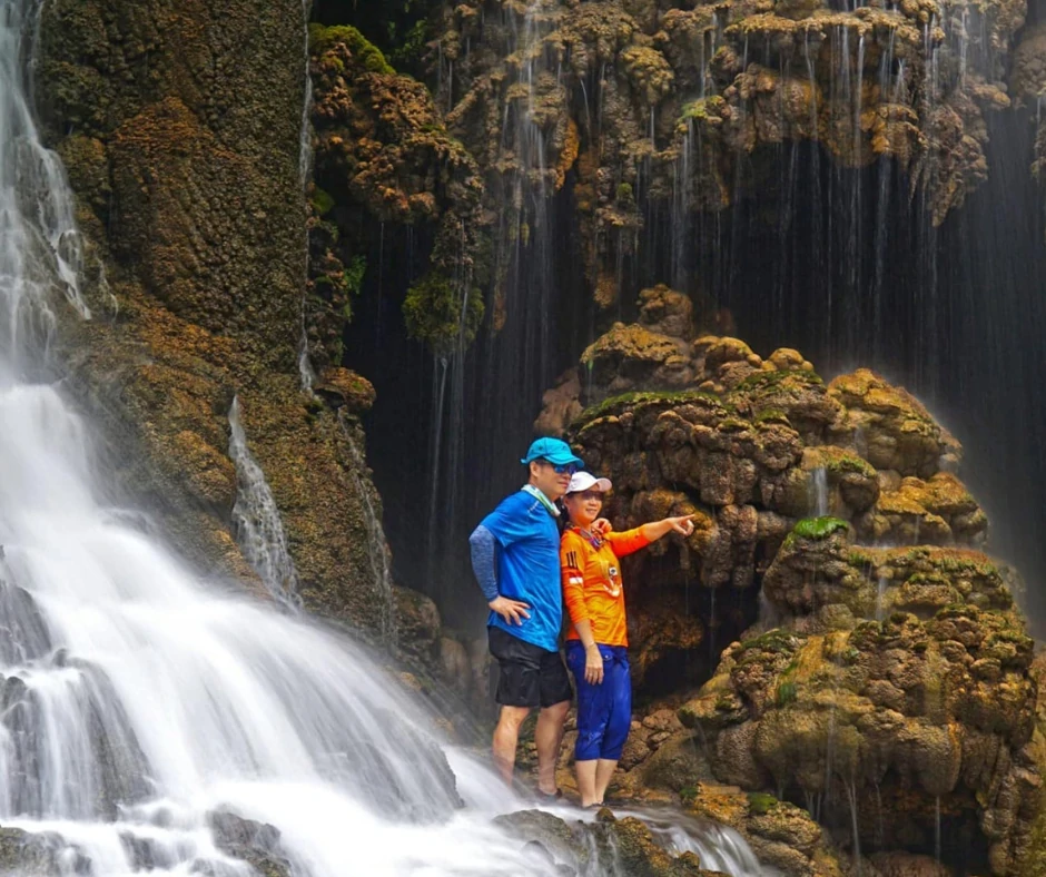 Tumpak Sewu waterfall cascading down into the pool, surrounded by lush greenery 3